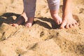 Mother and little baby feet on beach sand. Royalty Free Stock Photo