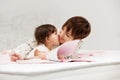Mother and little baby girl reading a book on bed Royalty Free Stock Photo