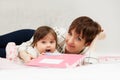 Mother and little baby girl reading a book on bed Royalty Free Stock Photo