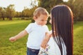 Mother with a little boy in her arms is smiling in the summer park. Royalty Free Stock Photo