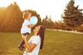 Mother with a little boy in her arms is smiling in the summer park. Royalty Free Stock Photo