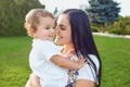 Mother with a little boy in her arms is smiling in the summer park. Royalty Free Stock Photo