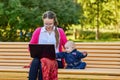 Mother with little boy makes remote work using laptop outdoors.