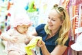 Mother with little child choosing baby apparel in shop Royalty Free Stock Photo