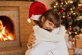 Mother and little child playing in Christmas, ladies wearing white sweaters, charming kid looks at camera with smile, kid