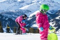 Mother and little child skiing in Alps mountains. Active mom and toddler kid with safety helmet, goggles and poles. Royalty Free Stock Photo