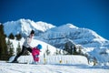 Mother and little child skiing in Alps mountains. Active mom and toddler kid with safety helmet, goggles and poles. Royalty Free Stock Photo