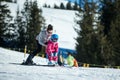 Mother and little child skiing in Alps mountains. Active mom and toddler kid with safety helmet, goggles and poles.