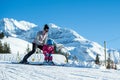 Mother and little child skiing in Alps mountains. Active mom and toddler kid with safety helmet, goggles and poles.