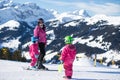 Mother and little child skiing in Alps mountains. Active mom and toddler kid with safety helmet, goggles and poles. Royalty Free Stock Photo