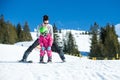 Mother and little child skiing in Alps mountains. Active mom and toddler kid with safety helmet, goggles and poles.