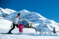 Mother and little child skiing in Alps mountains. Active mom and toddler kid with safety helmet, goggles and poles.