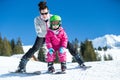 Mother and little child skiing in Alps mountains. Active mom and toddler kid with safety helmet, goggles and poles.