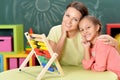 Mother with little daughter counting with abacus