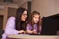 Woman and girl doing homework online. Distance learning online education. Mother and daughter happy together at home Royalty Free Stock Photo
