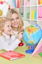 Portrait of mother with little daughter examine globe Royalty Free Stock Photo