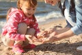 Mother and little daughter gathering shells near river Royalty Free Stock Photo