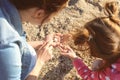 Mother and little daughter gathering shells near river Royalty Free Stock Photo