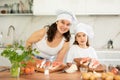 Mom and daughter in hats are preparing festive salmon dish Royalty Free Stock Photo