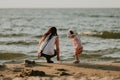 Mother and little daughter having fun on the beach. Authentic lifestyle image Royalty Free Stock Photo