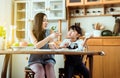 Mother and little daughter having fun with breakfast together at home kitchen in the morning,Healthy food Royalty Free Stock Photo