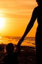 Mother and little daughter holding hands at sunset Royalty Free Stock Photo