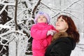 Mother with little daughter look up in woods