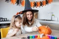 mother and little daughter playing and having fun during Halloween preparation at home