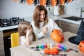 mother and little daughter playing and having fun during Halloween preparation at home