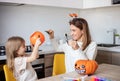 mother and little daughter playing and having fun during Halloween preparation at home