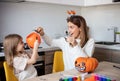 mother and little daughter playing and having fun during Halloween preparation at home