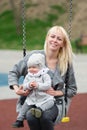 Mother with the little daughter shake on a swing.