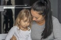 Mother and little daughter sit at the table and communicate. A woman calms a capricious child Royalty Free Stock Photo