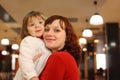 Mother with little daughter stand in cafe