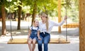 Mother And Little Daughter Swinging On Swings On Outdoor Playground Royalty Free Stock Photo