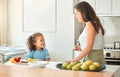 Mother and little daughter talking while mom teach her how to cook a vegetarian meal. Cooking with a little helper Royalty Free Stock Photo