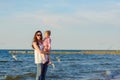 Mother and little daughter walking on the beach