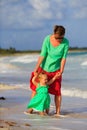 Mother and little daughter walking on summer beach Royalty Free Stock Photo