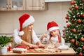 Mother and little girl baking Christmas pastry. Children bake gingerbread. Royalty Free Stock Photo