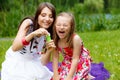 Mother and little girl blowing soap bubbles in park. Royalty Free Stock Photo