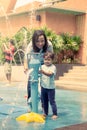 Mother and little girl having fun to play with water in park Royalty Free Stock Photo