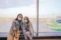 Mother and little girl with medical masks at airport. Protection against Coronavirus and gripp Royalty Free Stock Photo