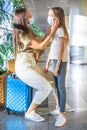 Mother and little girl with medical masks at airport. Protection against Coronavirus and gripp Royalty Free Stock Photo