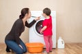 Mother with little girl near the washing machine Royalty Free Stock Photo