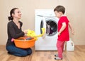 Mother with little girl near the washing machine Royalty Free Stock Photo