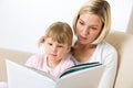 Mother with little girl read book together