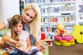 Mother with little girl read book together