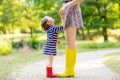 Mother and little girl in rubber boots having fun Royalty Free Stock Photo