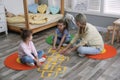 Mother and little girls taping sticker hopscotch on floor Royalty Free Stock Photo