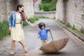 Mother and little handsome baby boy playing with umbrella outdoor in old town Royalty Free Stock Photo